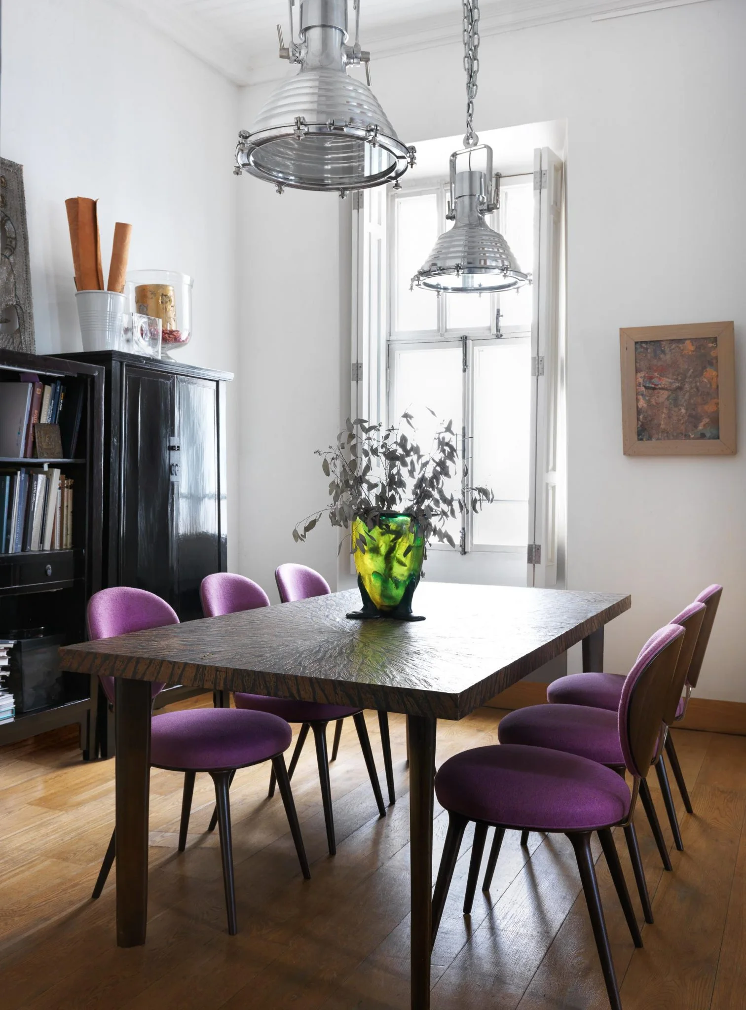Sala de reunión de una oficina en Moscú con mesa de madera, sillas moradas y obras de arte.