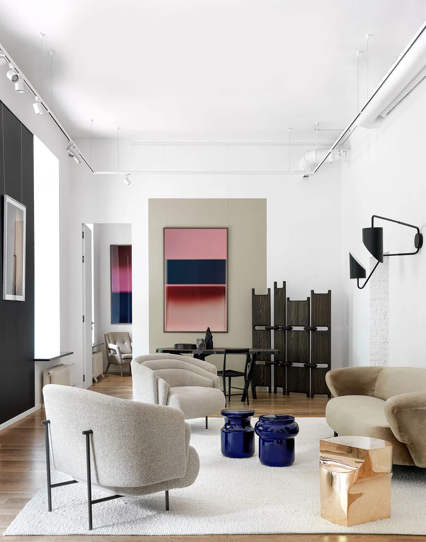 Interior de un salón de belleza en Moscú con sillones blancos y una obra geométrica rosa y azul.