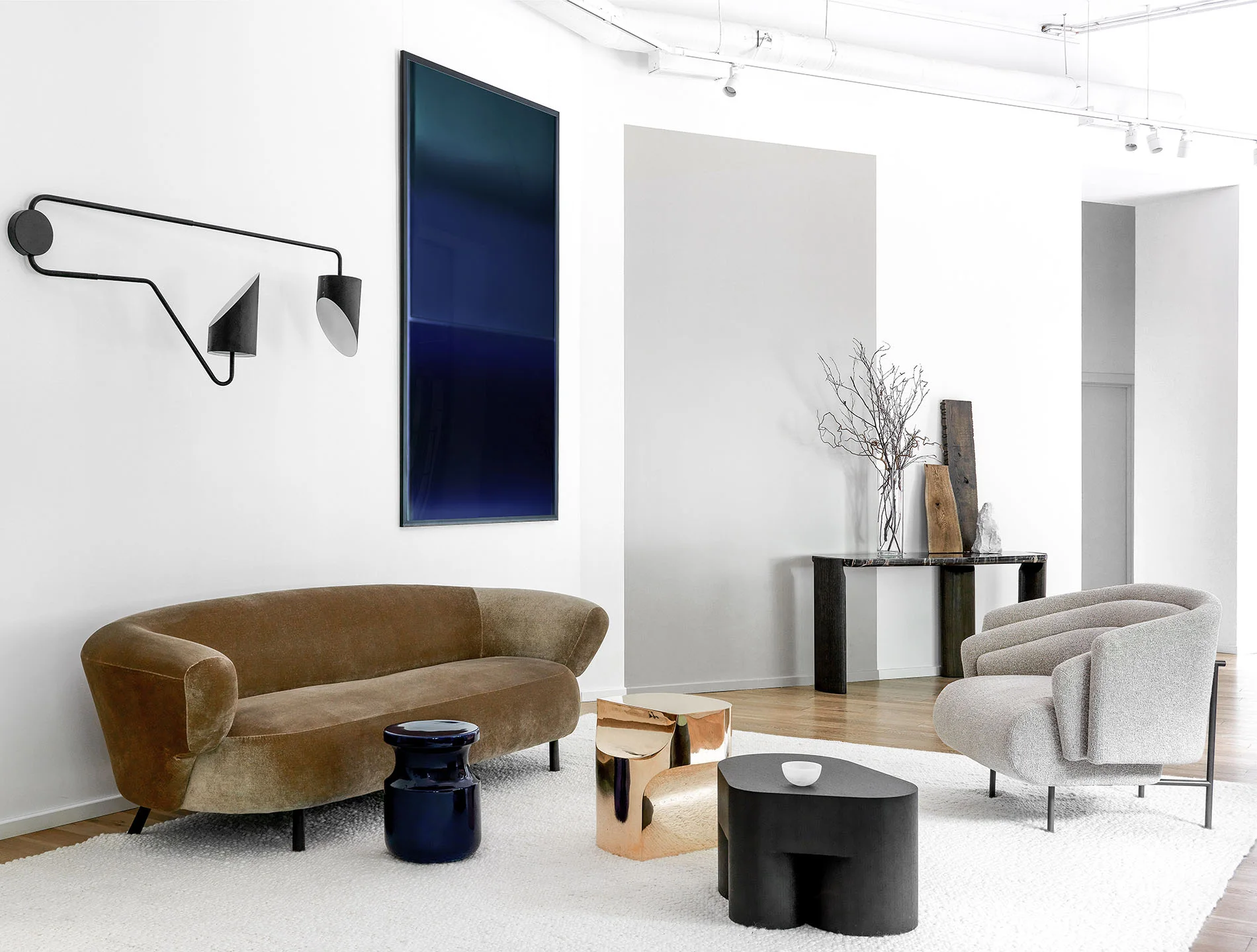 Zona de espera de un salón de belleza en Moscú con sofá de terciopelo, sillones blancos y pintura contemporánea.