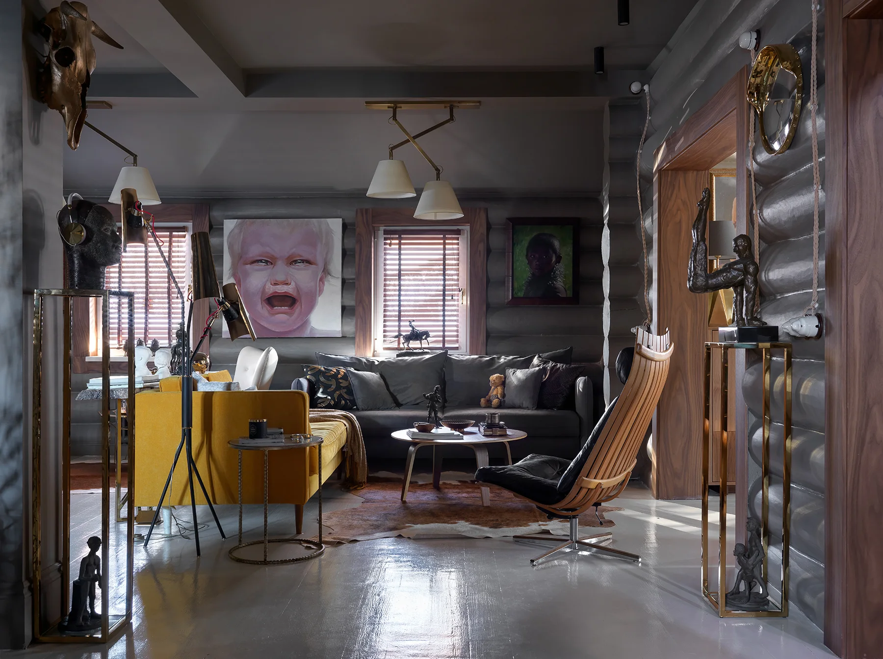 Salón oscuro de una vivienda en Moscú con una gran obra figurativa, sofá gris, silla amarilla y esculturas.