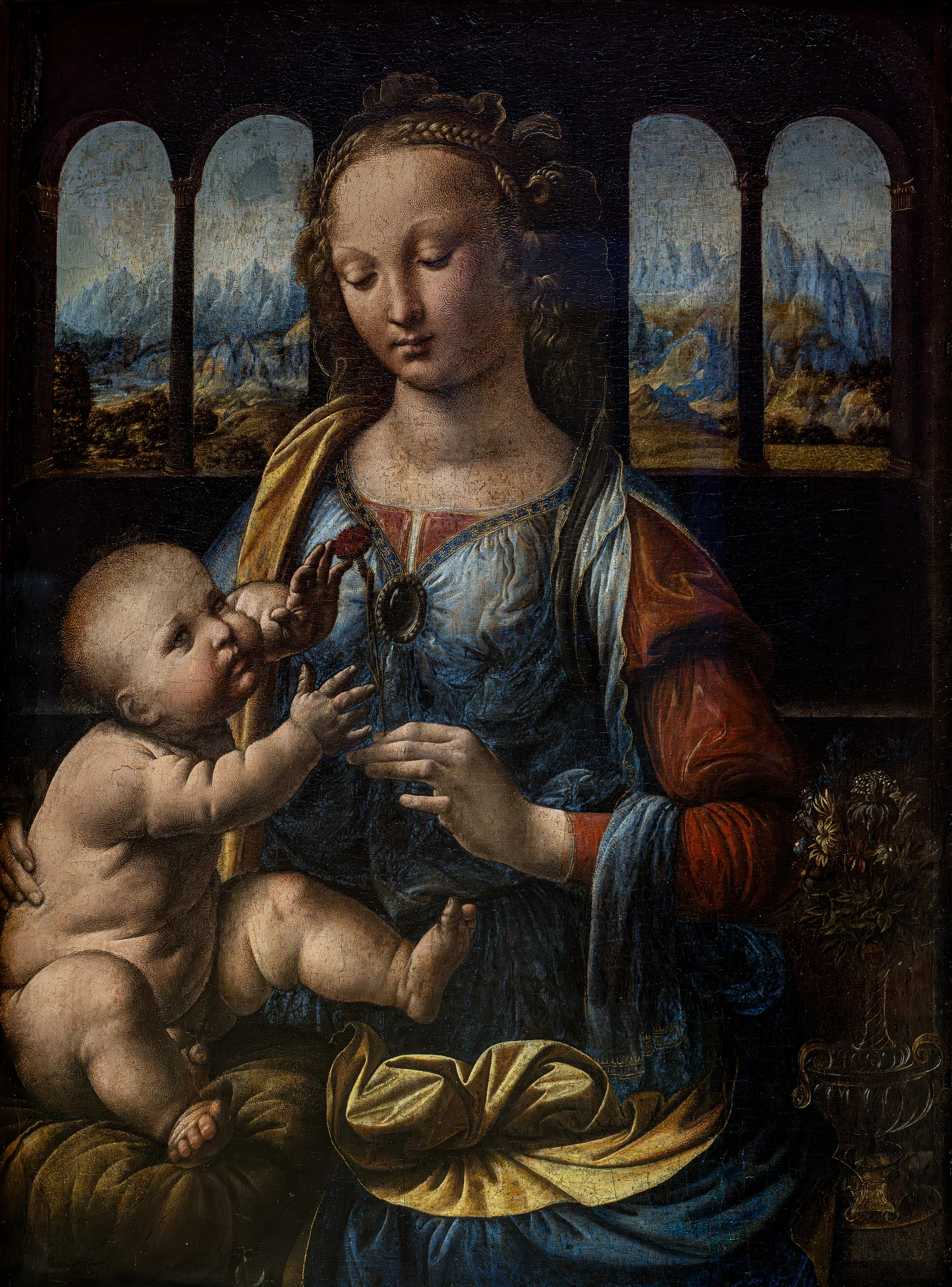 Madonna del clavel de Leonardo da Vinci, la Virgen sostiene al Niño frente a ventanas abiertas a un paisaje.
